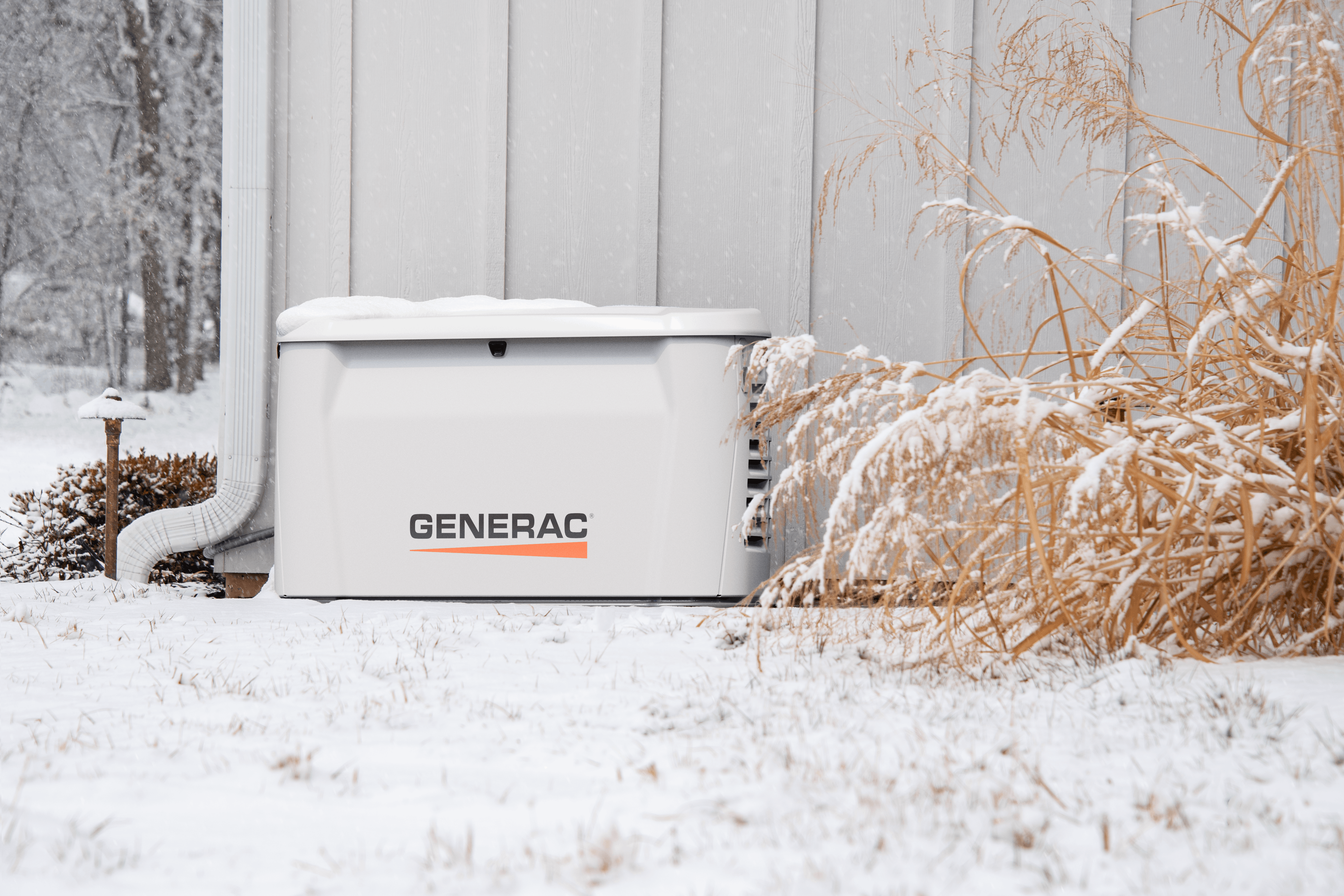 Generac standby generator installed outside a home in winter snow